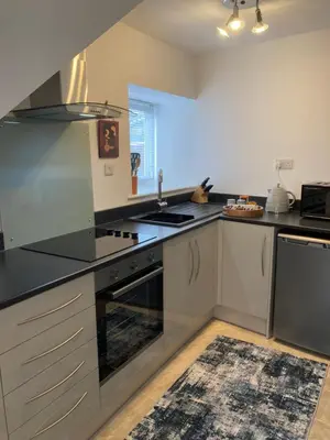 a kitchen with stainless steel appliances and a black counter top at Ludford View, riverside cottage in Ludlow with private parking in Ludlow