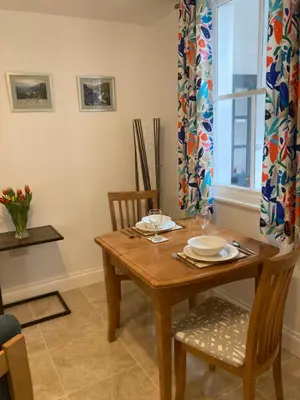 a dining room with a wooden table and chairs at Ludford View, riverside cottage in Ludlow with private parking in Ludlow