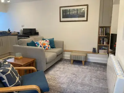 a living room with a couch and a table at Ludford View, riverside cottage in Ludlow with private parking in Ludlow