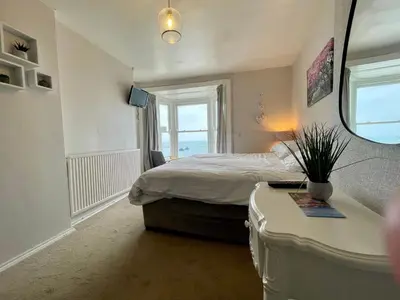 a bedroom with a bed and a desk with a mirror at Cranwell Court in Aberystwyth