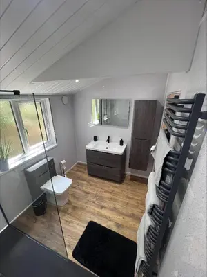 a bathroom with a sink and a toilet and a mirror at Awel Y Trydan Cottage in Pennant