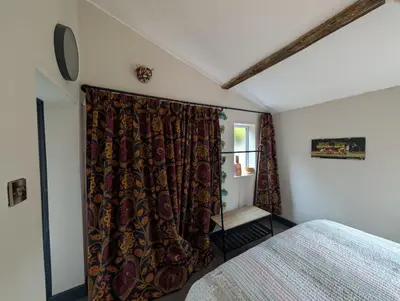 a bedroom with a bed and a curtain at Grosvenor Studio Apartment in Llandrindod Wells