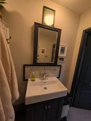 a bathroom with a sink and a mirror at Grosvenor Studio Apartment in Llandrindod Wells