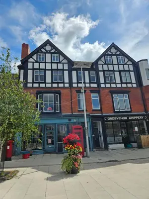 a black and white building with flowers in front of it at Grosvenor Studio Apartment in Llandrindod Wells