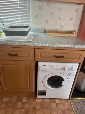 a kitchen with a washing machine in a counter at Static Caravan in Aberystwyth