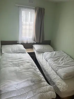 two beds in a room with a window at Static Caravan in Aberystwyth