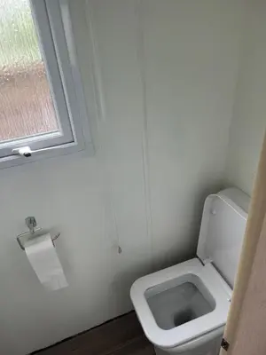 a small bathroom with a toilet and a window at Static Caravan in Aberystwyth