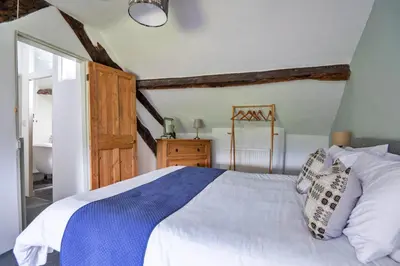 a bedroom with a white bed and a bathroom at Finest Retreats - Penclogwynau in Dolgellau