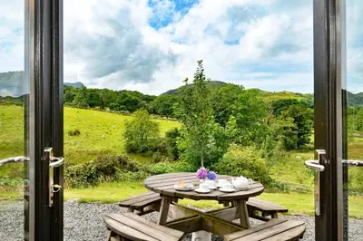 a picnic table with a view of a field at Finest Retreats - Penclogwynau in Dolgellau