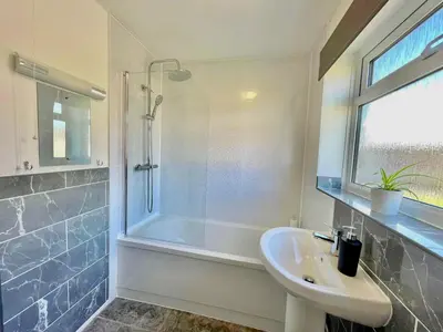 a bathroom with a sink and a shower at Your Leominster Base - 3BR Home with Garden & Parking in Leominster