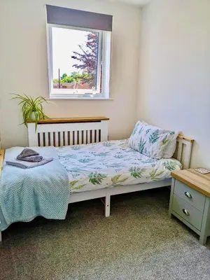a bedroom with a bed and a window at Your Leominster Base - 3BR Home with Garden & Parking in Leominster