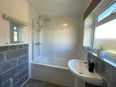a bathroom with a tub and a sink and a shower at Your Leominster Base - 3BR Home with Garden & Parking in Leominster
