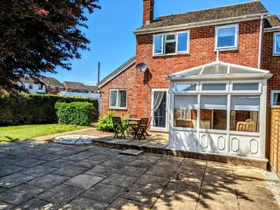 a brick house with a conservatory in the yard at Your Leominster Base - 3BR Home with Garden & Parking in Leominster