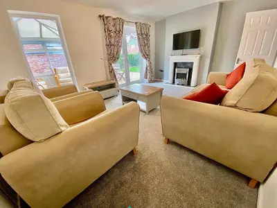 a living room with two couches and a fireplace at Your Leominster Base - 3BR Home with Garden & Parking in Leominster