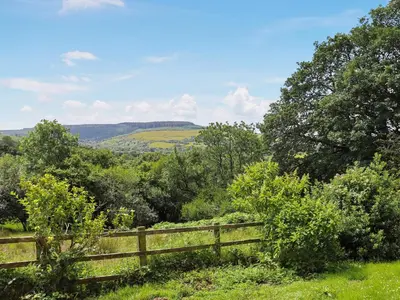a wooden fence in the middle of a field at Thatched Cottage - Uk50261 in Llandeilo