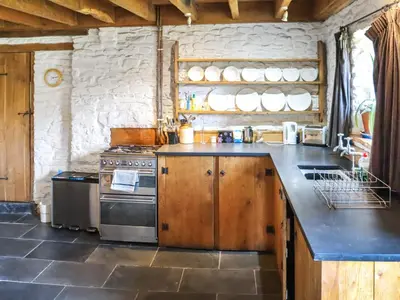 a kitchen with a stove and a counter top at Thatched Cottage - Uk50261 in Llandeilo