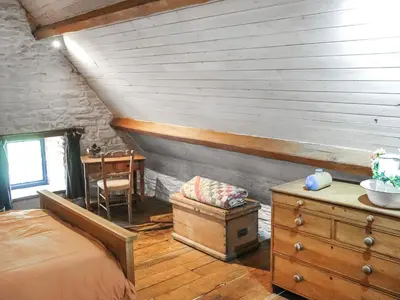a bedroom with a bed and a table in a room at Thatched Cottage - Uk50261 in Llandeilo