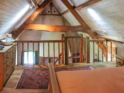 an attic room with wooden beams and a staircase at Thatched Cottage - Uk50261 in Llandeilo