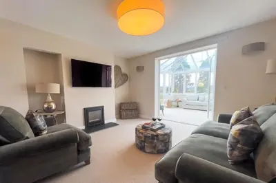a living room with two couches and a fireplace at Wellingtonia Cottage in Chirbury