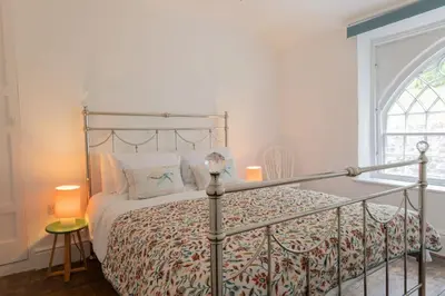 a bedroom with a bed and a window at Charming Eco Hideaway on the Dee River with Private Relaxing Hot Tub in Llangollen