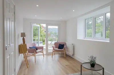 a living room with two chairs and a table at Charming Eco Hideaway on the Dee River with Private Relaxing Hot Tub in Llangollen