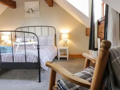 a bedroom with a bed and a chair at Cyffdy Cottage - Aran in Bala