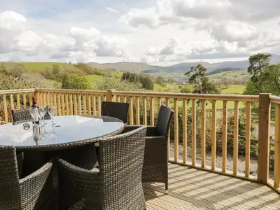 a table and chairs on a deck with a view at Cyffdy Cottage - Aran in Bala