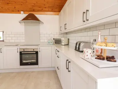 a kitchen with white cabinets and a counter top at Cyffdy Cottage - Tegid in Bala