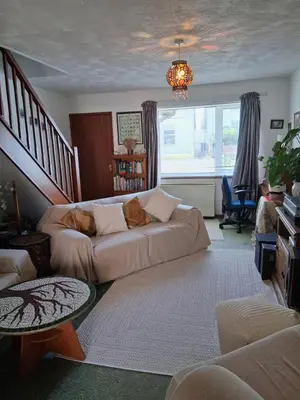 a living room with a couch and a table at King bed, opposite the beach in Borth