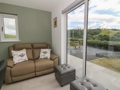 a living room with a couch and a large window at Rydlan in Aberystwyth