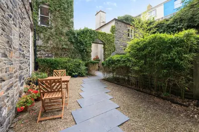 a garden with a stone walkway next to a building at two bed Seafront apartment - sea views in Aberystwyth