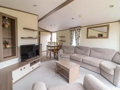 a living room with a couch and a tv at Beach Retreat E19 Dyffryn Seaside Estate in Dyffryn