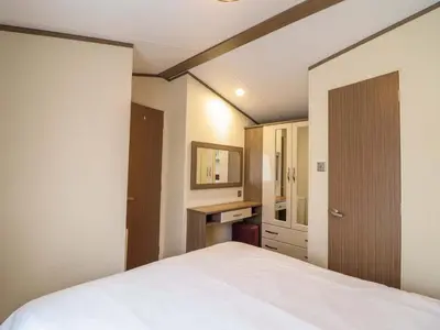 a bedroom with a white bed and a desk at Beach Retreat E19 Dyffryn Seaside Estate in Dyffryn