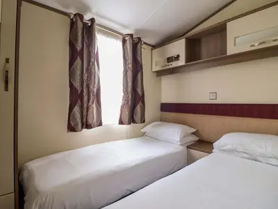 two beds in a small room with a window at Beach Retreat E19 Dyffryn Seaside Estate in Dyffryn