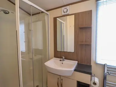 a bathroom with a sink and a shower at Beach Retreat E19 Dyffryn Seaside Estate in Dyffryn