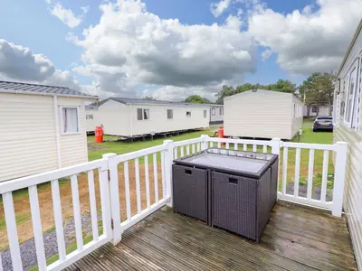 a balcony with a trash can on a wooden deck at Beachcombers Barmouth Bay Holiday Park in Talybont