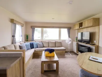 a living room with a couch and a tv at Beachcombers Barmouth Bay Holiday Park in Talybont