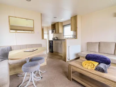 a living room with a table and a couch at Beachcombers Barmouth Bay Holiday Park in Talybont