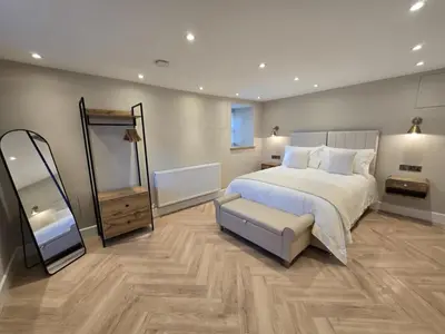 a large bedroom with a bed and a mirror at Modern Retreat near Aberaeron - Luxe 1 bed Escape in Ciliau-Aeron