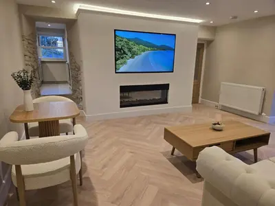 a living room with a fireplace and a tv on the wall at Modern Retreat near Aberaeron - Luxe 1 bed Escape in Ciliau-Aeron