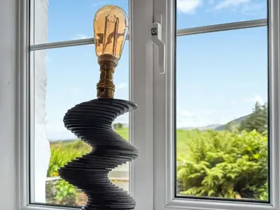 a wavy hurricane coil in front of a window at Tegfryn Cottage in Tanygrisiau