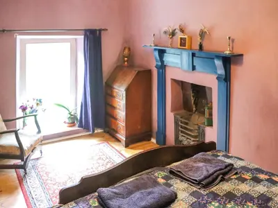 a living room with a bed and a fireplace at Farm House - Uk50262 in Llandeilo