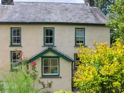 an old house with black windows and flowers at Farm House - Uk50262 in Llandeilo