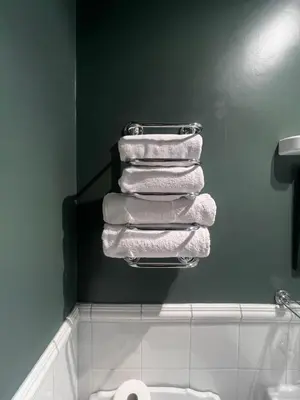 a bathroom with a stack of towels on a rack at Cantre Selyf in Brecon