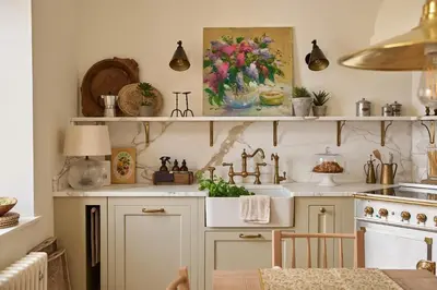 a kitchen with white cabinets and a painting of flowers at Castle Corner, The Georgian House in Ludlow