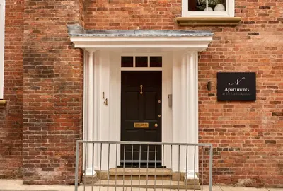 a front door of a brick building with a black door at Castle Corner, The Georgian House in Ludlow