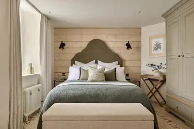 a bedroom with a large bed with a large headboard at Market View - The Georgian House in Ludlow