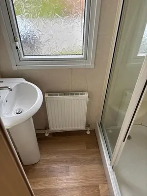 a bathroom with a sink and a window at Clarach Bay Escape 3 Bedroom PetFriendly Caravan with Decking Sleeps 6 in Aberystwyth