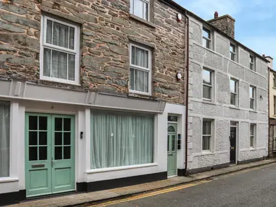 a row of houses with green doors on a street at Apartment Two - Uk49592 in Bala