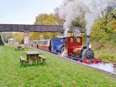 a train traveling down the tracks with smoke coming at Apartment Two - Uk49592 in Bala